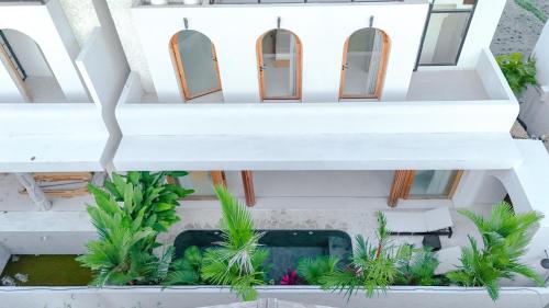 an overhead view of a white building with plants at Modern 1BR with Rooftop Rice Fields & Seseh Beach Panorama in Cemagi