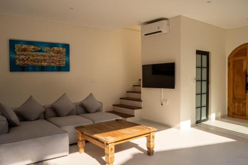 a living room with a couch and a table at Modern 1BR with Rooftop Rice Fields & Seseh Beach Panorama in Cemagi