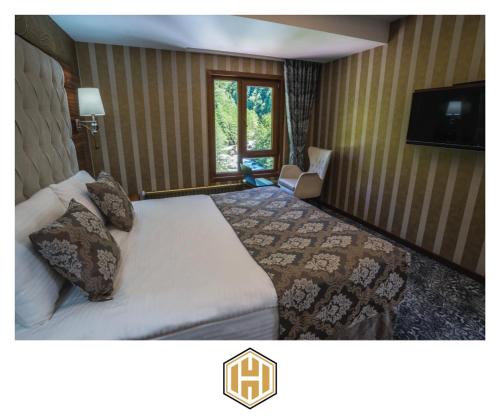 a hotel room with a bed and a window at Ayder Hasimoglu Hotel in Ayder Yaylasi