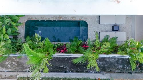 a swimming pool with plants in front of a building at Modern 1BR with Rooftop Rice Fields & Seseh Beach Panorama in Cemagi