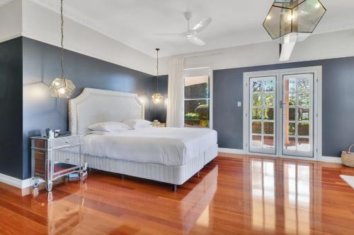 a bedroom with a white bed and blue walls at Expansive Cotswold Hills Retreat with Garden BBQ in Charlton