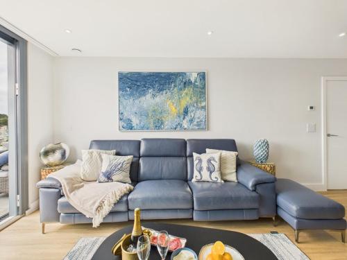 a living room with a blue couch and a table at Skydeck at The Liner – Stylish 2-Bed / 2-Bath Top Floor with Panoramic Sea Views in Falmouth