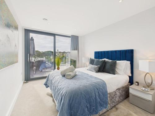 a bedroom with a large bed and a large window at Skydeck at The Liner – Stylish 2-Bed / 2-Bath Top Floor with Panoramic Sea Views in Falmouth