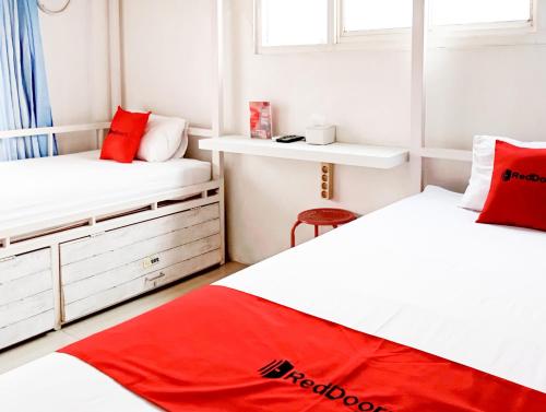 two beds in a small room with red pillows at RedDoorz Hostel at Luna Bunkbed Malioboro in Jarakan