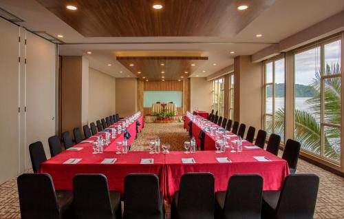 a conference room with a long table with red tablecloths at Swiss-Belhotel Papua in Jayapura