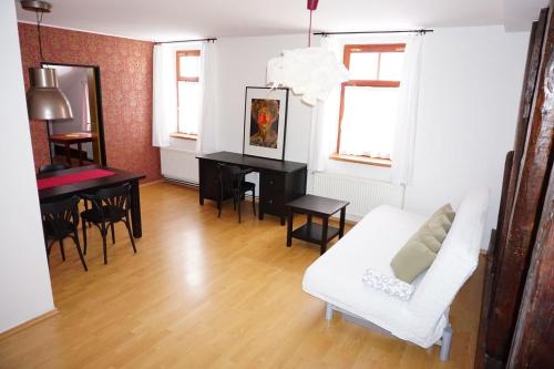 a living room with a white couch and a table at Apartmá v Rodném domě Vincenze Priessnitze v centru lázní in Jeseník