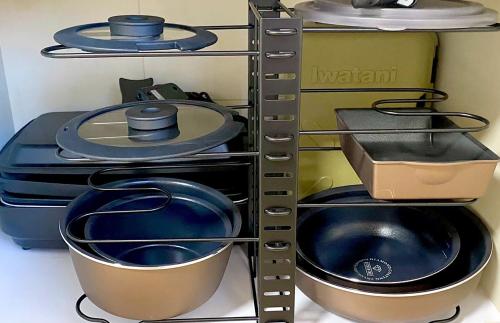 a shelf with pots and pans on it at Spacious Family Home Near Beach Park & Playground in Hasunuma