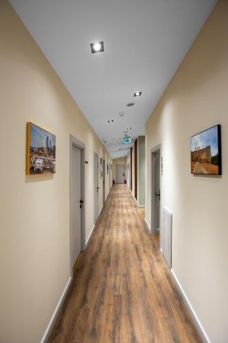 an empty corridor in a building with wooden floors at Capital City Hotel in Baku