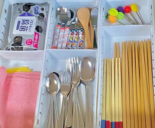 a plastic container filled with utensils and spoons at Spacious Family Home Near Beach Park & Playground in Hasunuma