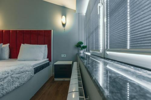 a bedroom with a bed and a bath tub next to a window at Capital City Hotel in Baku