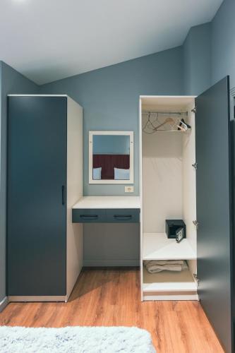 a bedroom with blue walls and a mirror at Capital City Hotel in Baku