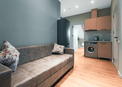 a living room with a couch and a kitchen at Capital City Hotel in Baku