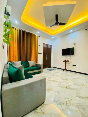 a living room with a couch and a flat screen tv at Sahas Villa in Talalla