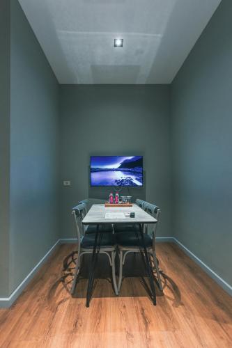 a dining room with a table with chairs and a tv at Capital City Hotel in Baku