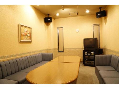 a room with a couch and a table and a tv at Ako Park Hotel in Ako