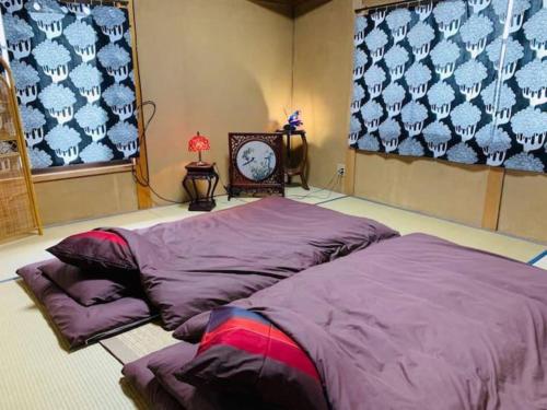 鳥栖市にあるHouse Hatama - Vacation STAY 15850のベッド2台と壁掛け時計が備わる客室です。