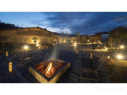 a fire pit in the middle of a patio at night at Kyoto Keburikawa Hotel in Kameoka