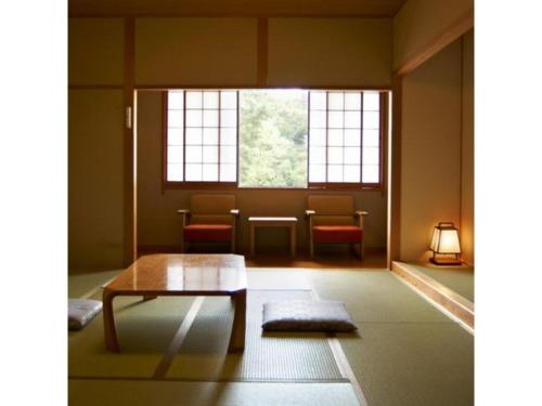 a room with a table and chairs and a window at Kyoto Keburikawa Hotel in Kameoka