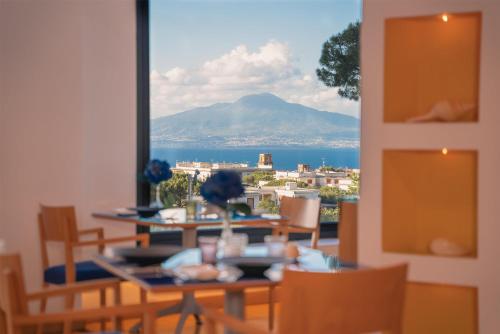 a dining room with a view of a mountain at Hilton Sorrento Palace in Sorrento