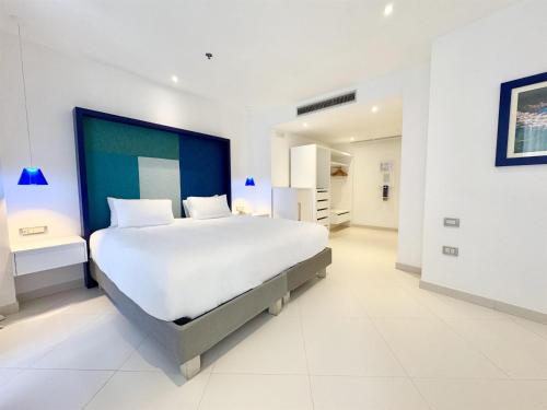 a large white bedroom with a large white bed at Hilton Sorrento Palace in Sorrento