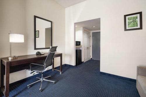 a hotel room with a desk and a chair at Wingate by Wyndham Augusta Fort Eisenhower in Augusta