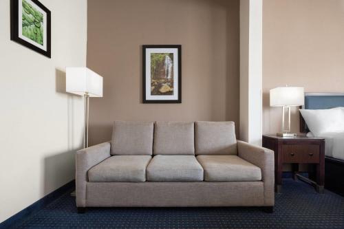 a living room with a couch in a hotel room at Wingate by Wyndham Augusta Fort Eisenhower in Augusta