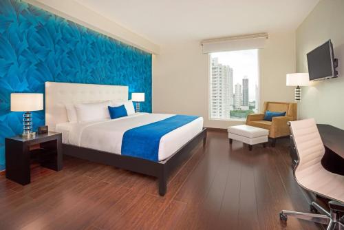 a bedroom with a bed and a desk and a chair at Ramada Plaza by Wyndham Panama Punta Pacifica in Panama City