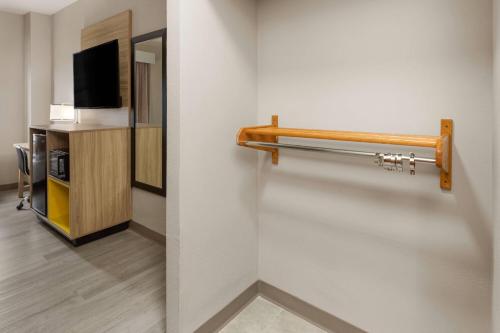 a hotel room with a towel rack and a tv at Days Inn by Wyndham Tulsa Central in Tulsa