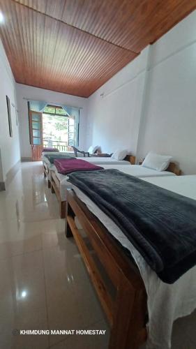 a room with a row of beds in a room at Khimdung Mannat Homestay in Mangpu