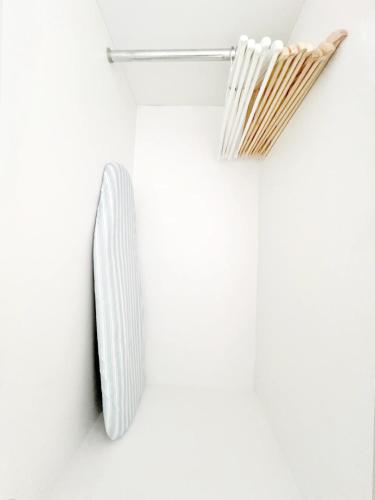 a white wall with a shelf and a whisk at HeiStay-30sec from Hongdae SubwayStop-Elevator in Seoul