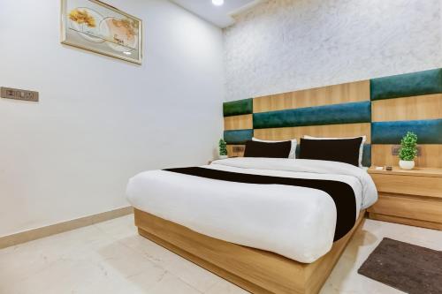 a bedroom with a large bed with a wooden headboard at Hotel O S.C HEIGHTS in Amritsar