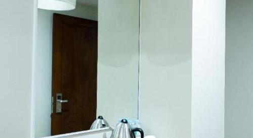 a bathroom mirror with a reflection of a door at Hotel Fleur de Liz in Panglao