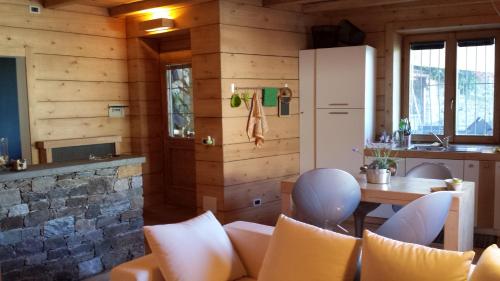 uma cozinha com paredes de madeira e uma mesa e cadeiras em Appartamento Le Chalet em Albosaggia