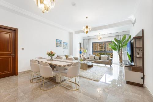 a dining room and living room with a table and chairs at Fairmont North 2BR 2 Balconies Sea View in Dubai