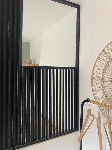 un miroir accroché au mur à côté d'un radiateur dans l'établissement Comfortable studio - Montbrison, à Montbrison