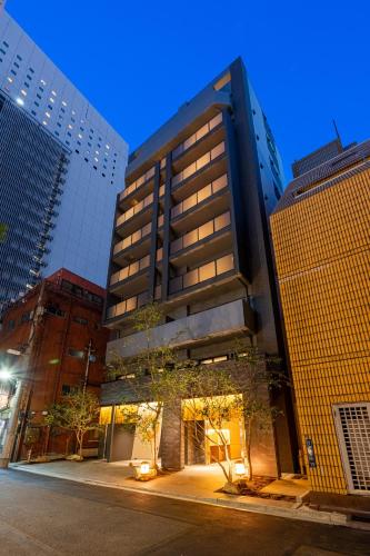 a tall building in the middle of some buildings at Hotel TOKI 季 in Tokyo