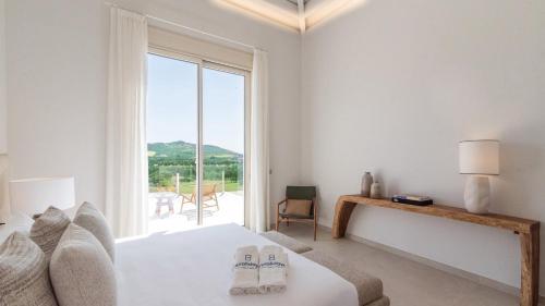 a white bedroom with a bed and a large window at Villa Selena Antequera by Ruralidays in Antequera
