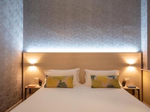 a bedroom with a large bed with two pillows at Hotel Embassy in Pero