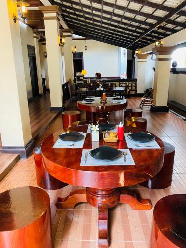 Un comedor con mesas y sillas de madera. en Maison Vongprachan Legend, en Luang Prabang