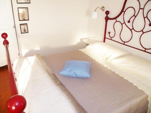 a bed with a blue pillow sitting on it at B&B Colle di Terria Country House in Contigliano