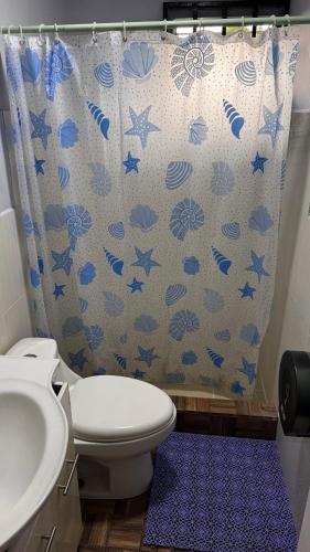 a bathroom with a toilet and a shower curtain at Peace N' Green in David