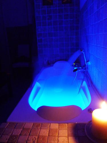 a blue bath tub with a candle in a bathroom at B&B Colle di Terria Country House in Contigliano
