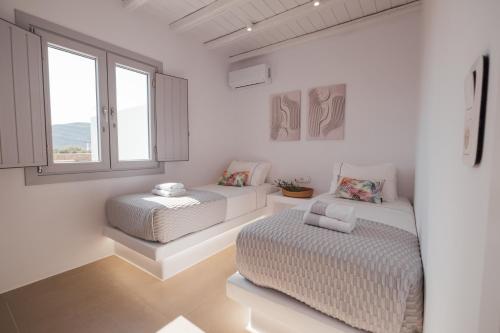a white room with a couch and a bed at Xerolithos Natural Living in Naxos Chora