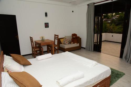 a bedroom with a bed and a table and a chair at Tranquile Viwe in Gonapinuwala West