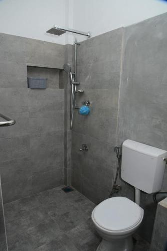 a bathroom with a toilet and a shower at Tranquile Viwe in Gonapinuwala West
