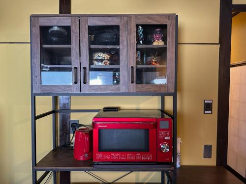 a red microwave sitting on a table next to a cabinet at TRAVELERZYOKOHAMA - Vacation STAY 10531v in Yokohama