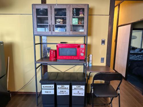 a red microwave sitting on a shelf in a room at TRAVELERZYOKOHAMA - Vacation STAY 10531v in Yokohama