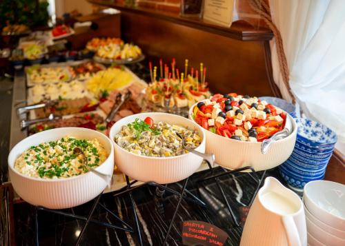 three bowls of food sitting on top of an oven at Hotel Polonia in Kraków