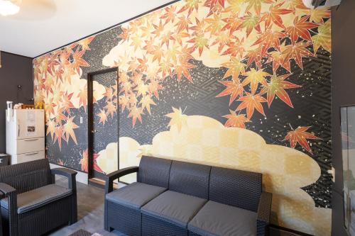 a room with a wall with a mural of a cloud at A home ゲストハウスすえ in Mashizume