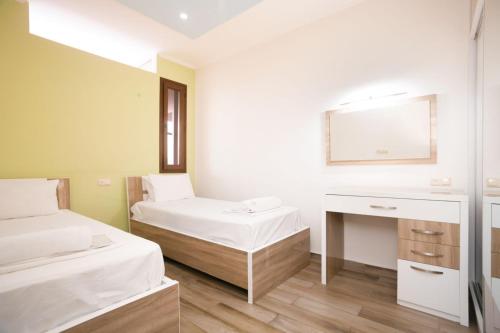 a room with two beds and a desk with a mirror at Stylish 2 Bedroom! Heart of city!! in Yerevan